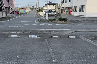 右手に赤いビルのシロタビルが見えてきます。右折して入り、番号32・33番に駐車してください。